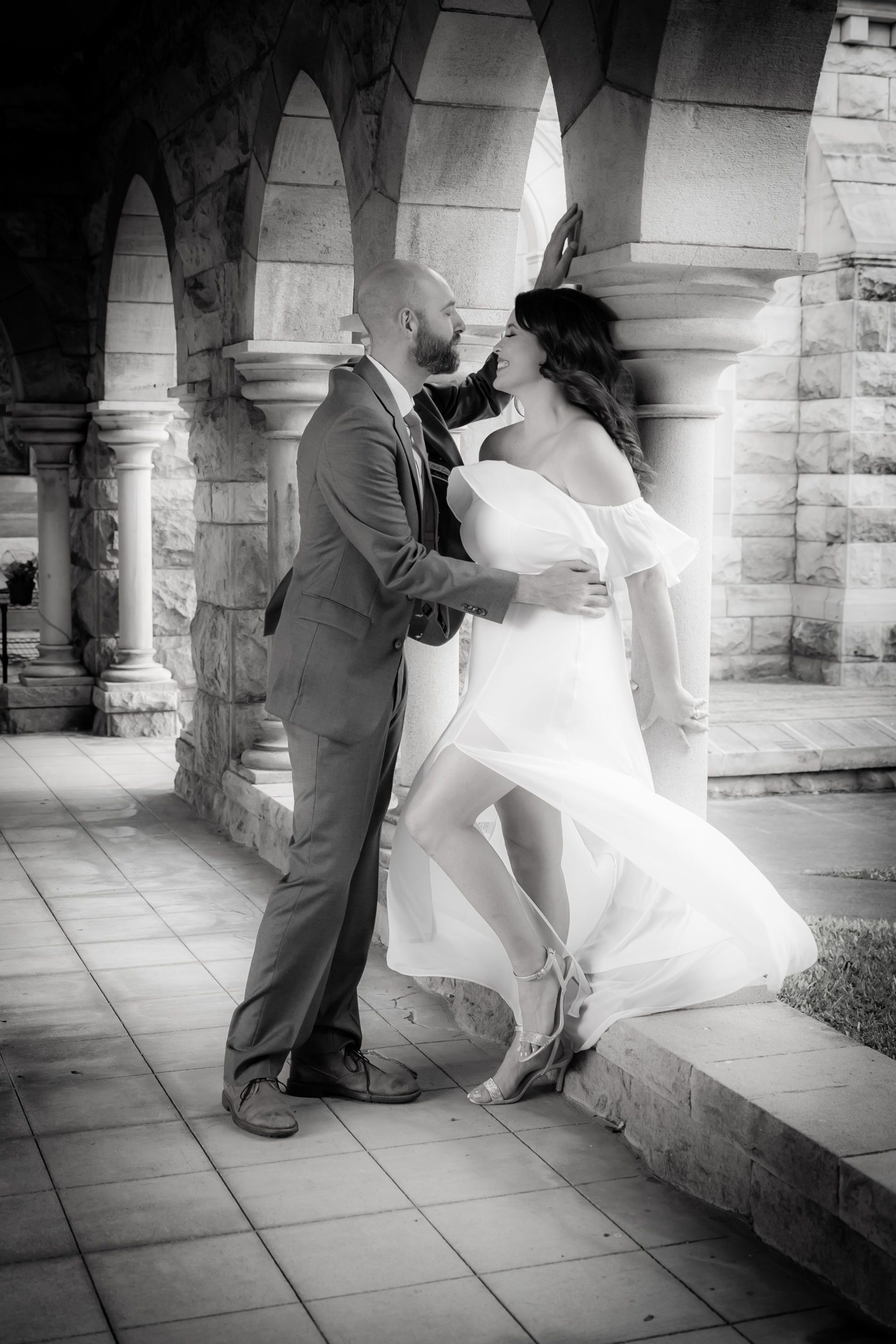 Newlyweds framed by a stone archway after their ceremony