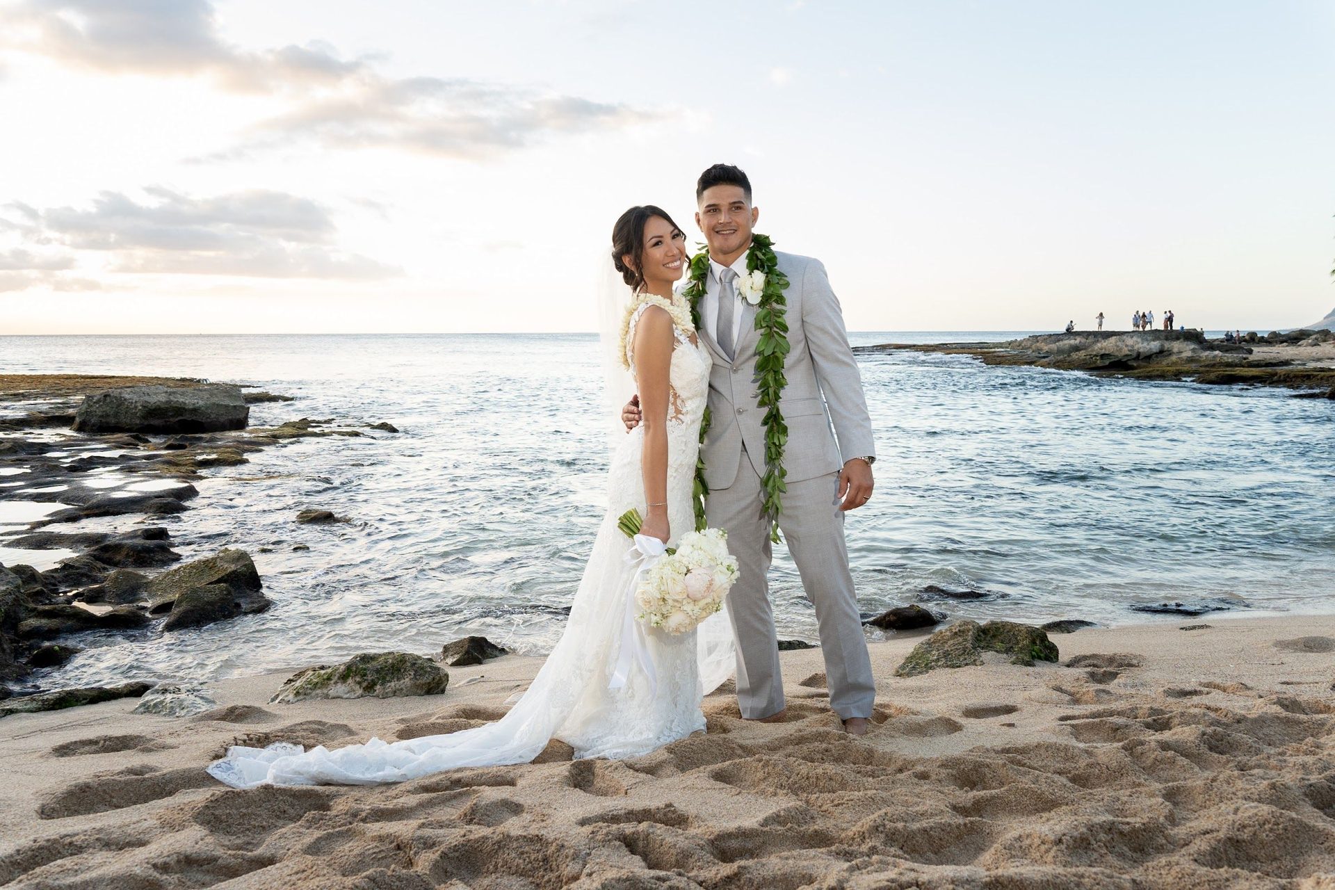 Couple embracing on volcanic rocks by the sea on Oʻahu