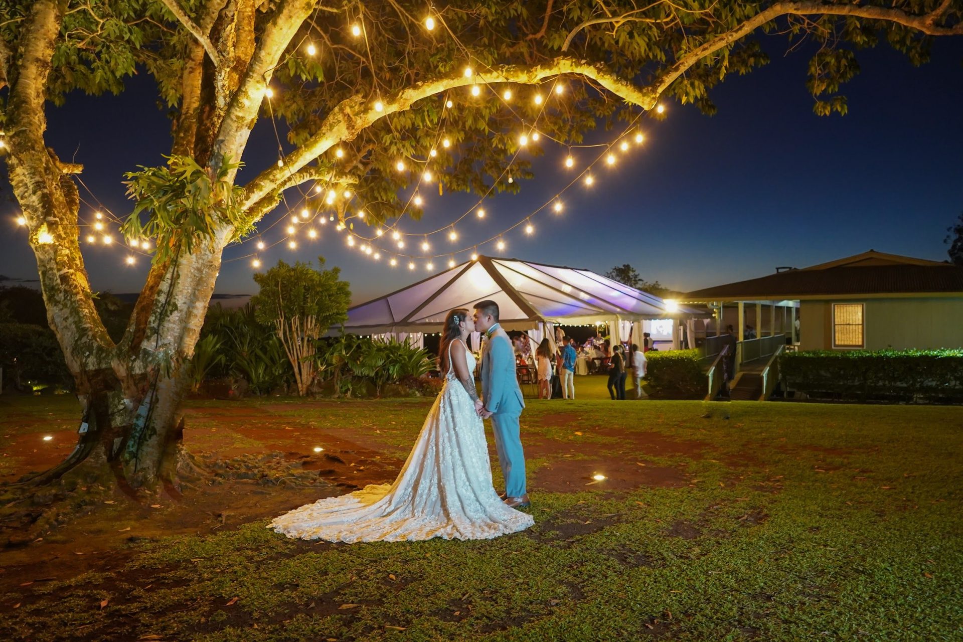 Newlyweds sharing their first dance beneath warm lights