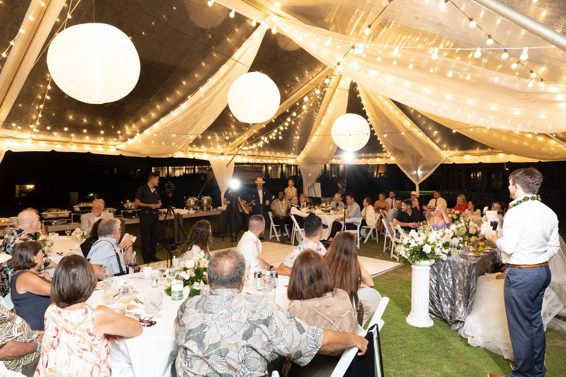 Reception under a tent with warm lights and guests
