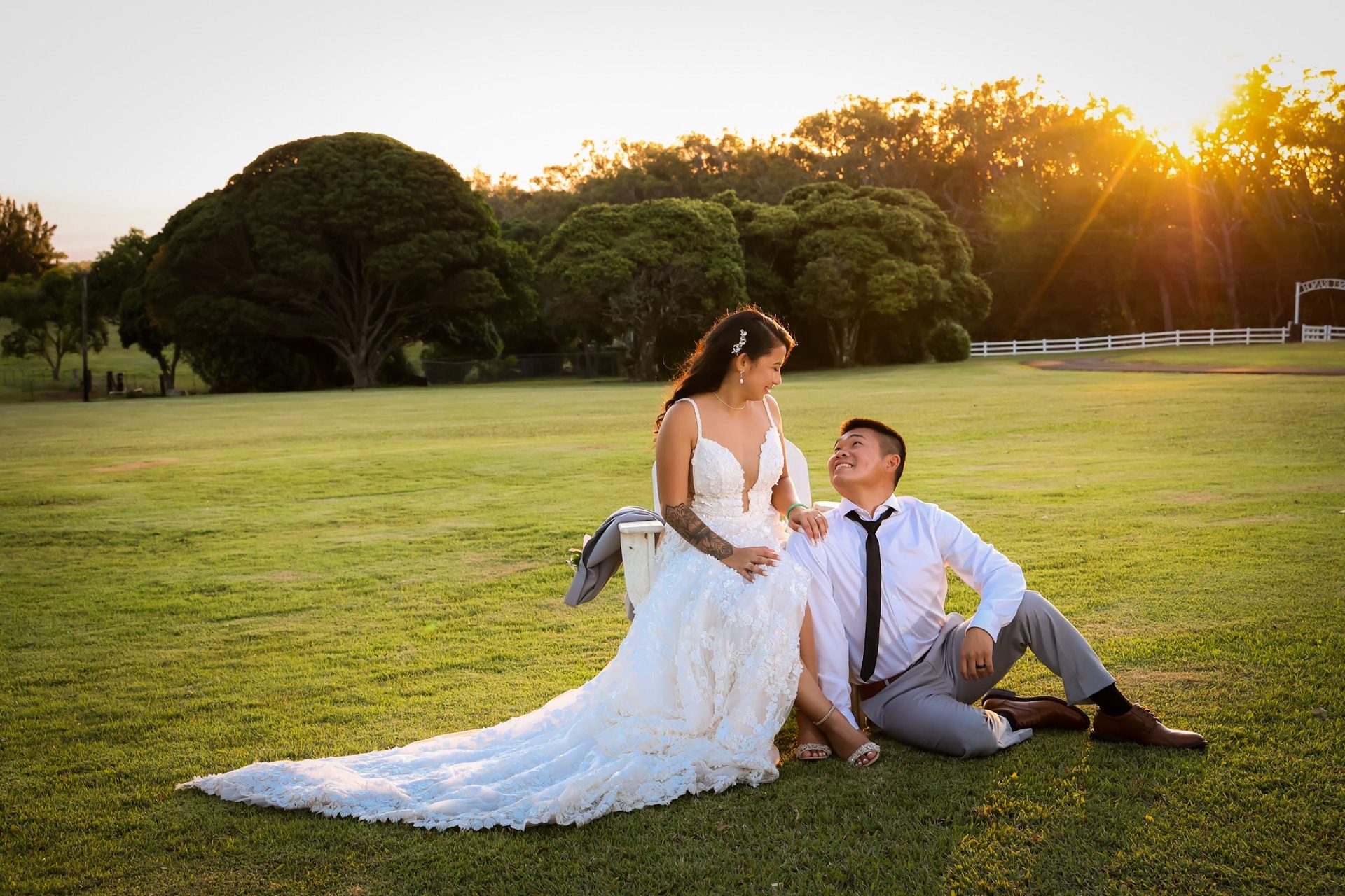 Groom dipping the bride in a garden at sunset